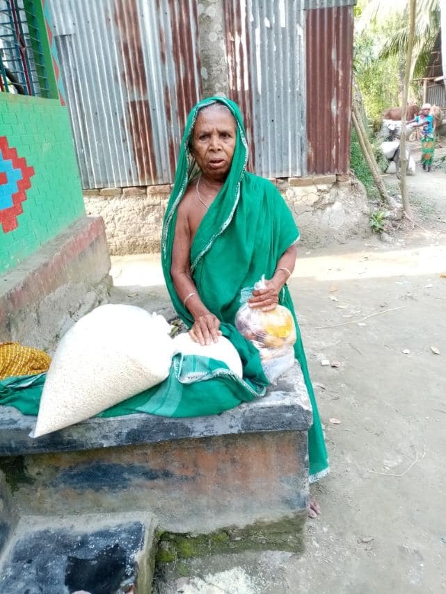 A recipient sitting with food packages