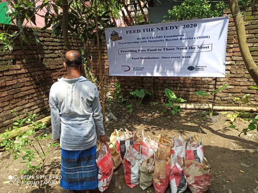 Food supplies beneath a Feed the Needy project banner