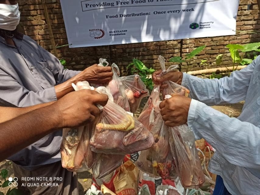 A volunteer handing over food supplies